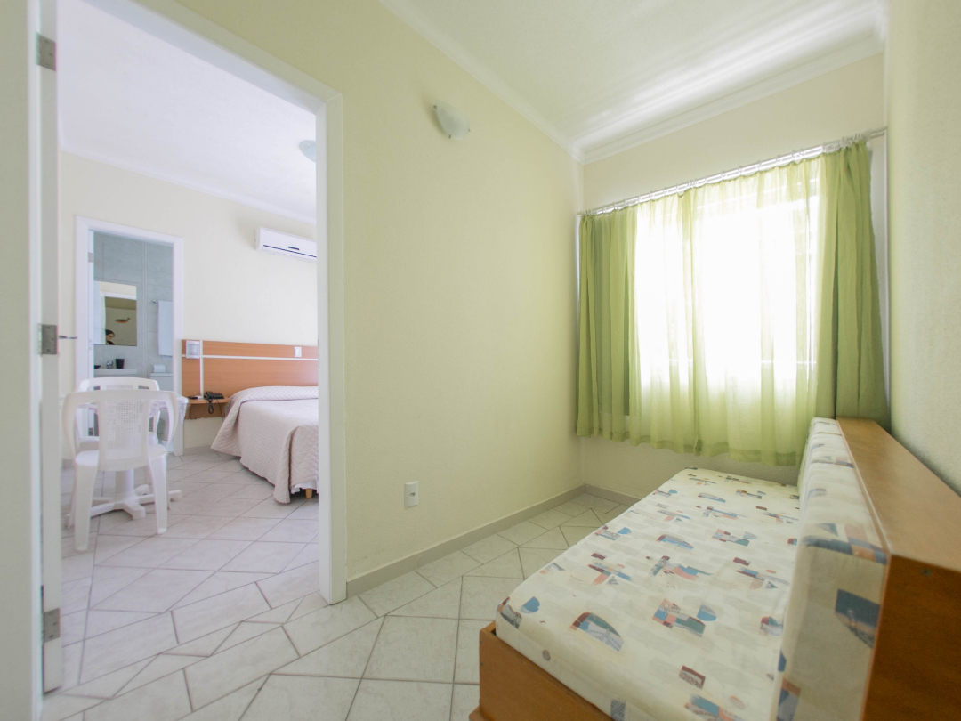 Foto da suíte família com varanda no Bombinhas Praia Apart Hotel II mostrando o quarto e o bicama
