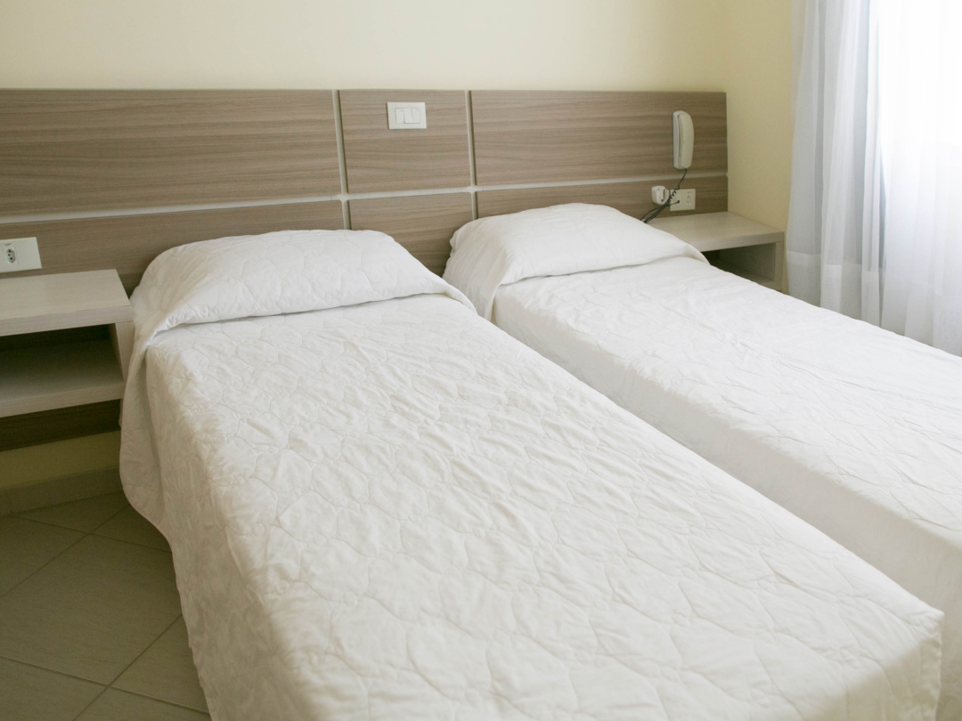 Foto da suíte sem varanda no Bombinhas Praia Apart Hotel II mostrando camas de solteiro
