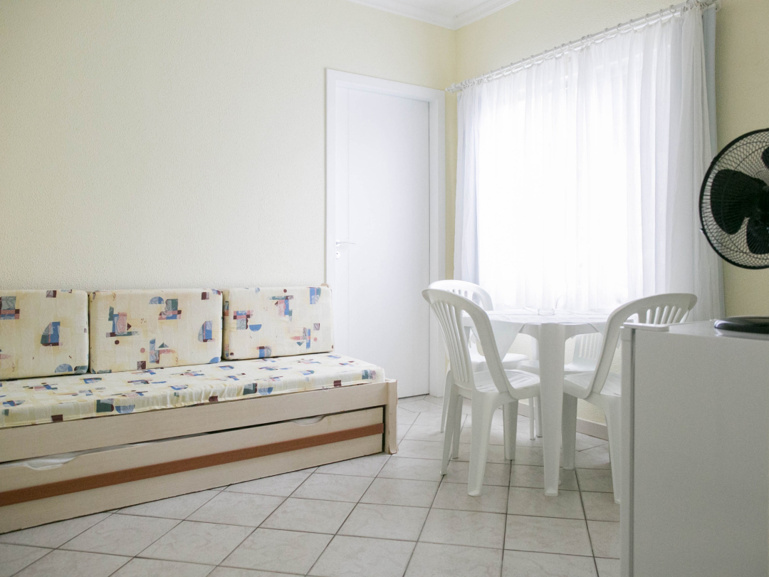 Foto do apartamento família no Bombinhas Praia Apart Hotel II mostrando a sala, o bicama, mesa e o frigobar